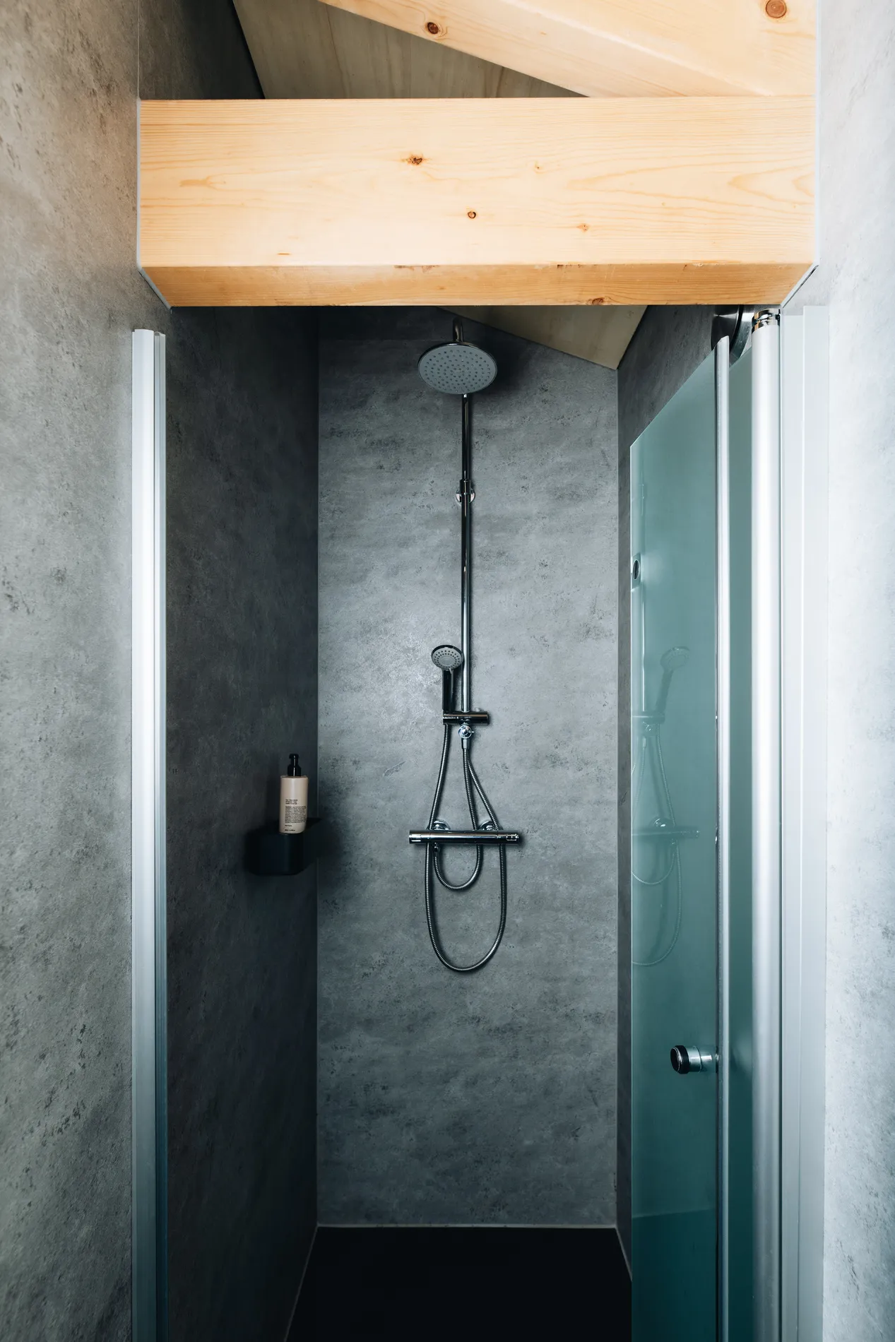 Detailopname van de inloopdouche met grijze natuursteen-look tegels.